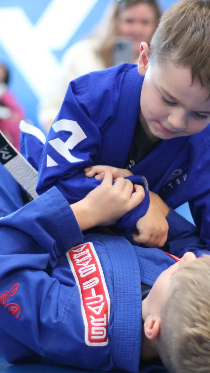 A kids class training while parents watch from the side