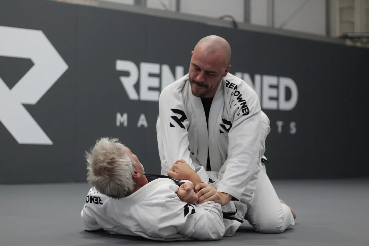 A coach holding a controlled position while working through a technique with a student